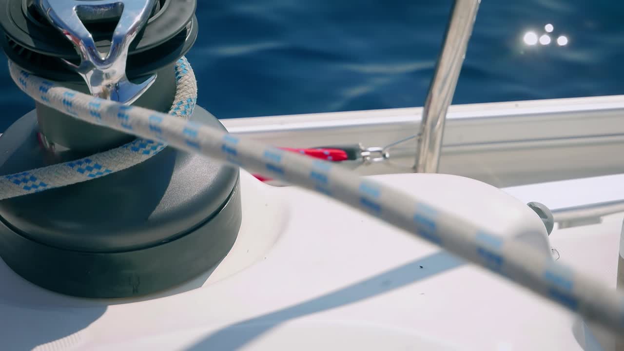 Rope Being Pulled Through A Winch Of A Boat Sailing Over The Sea - close up