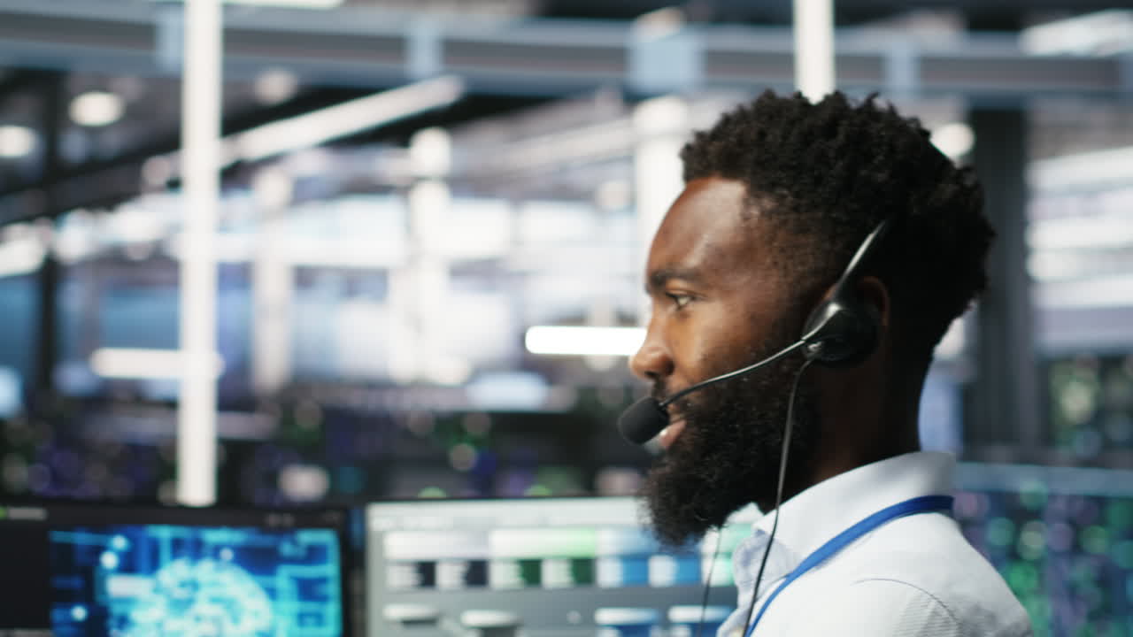 Data center employee talking in headset mic, coordinating technicians
