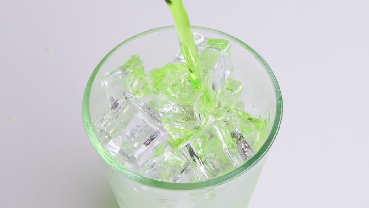 유리에 청량 음료와 녹색 소다를 붓는 o 흰색 배경