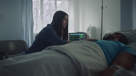 woman comfort sick man in hospital ward. modern clinic operating room interior.