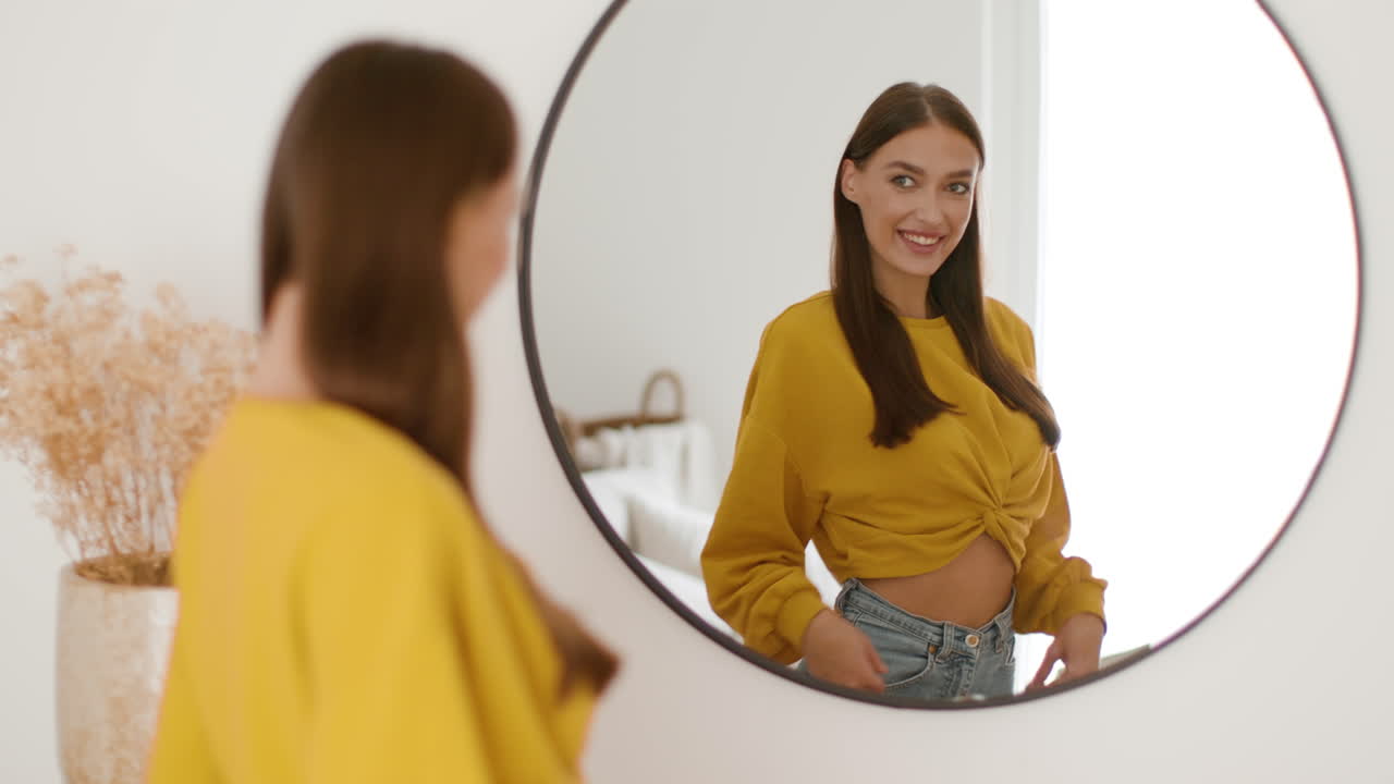 Woman looking at herself in a mirror while dressing