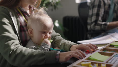 young caucasian business woman mother playing with baby daughter at work playful toddler enjoying loving mom successful motherhood in office workplace