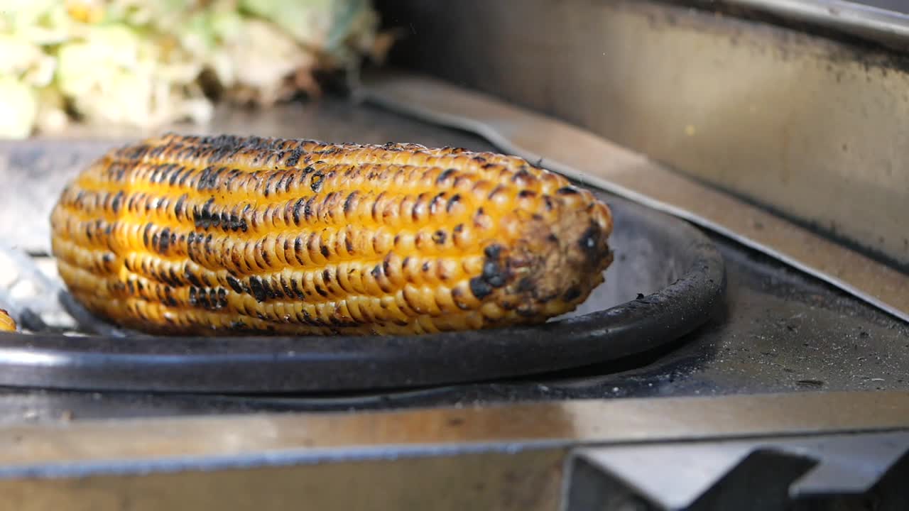 maíz a la parrilla en una parrilla de un vendedor callejero