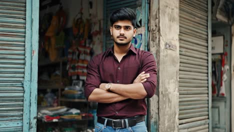 young entrepreneur standing confidently in front of small business storefront, arms crossed, embodying success and determination with professional demeanor