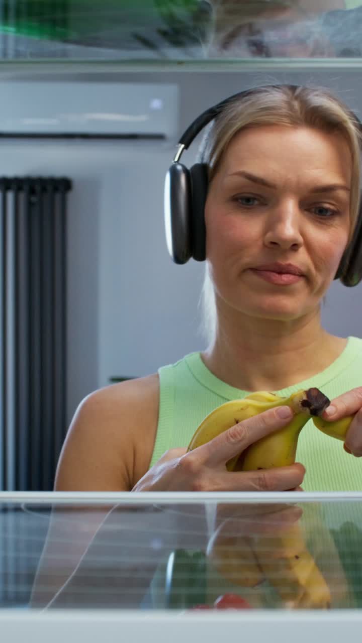 Woman Reaching for Bananas in a Refrigerator