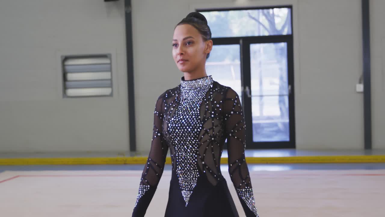 십대 여성 체조 선수 가 스포츠 홀 에서 공연 하고 있다