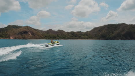 una toma cinematográfica en cámara lenta de un waverunner amarillo cabalgando a través de las claras aguas azules en las filipinas, asia, slomo, jet ski