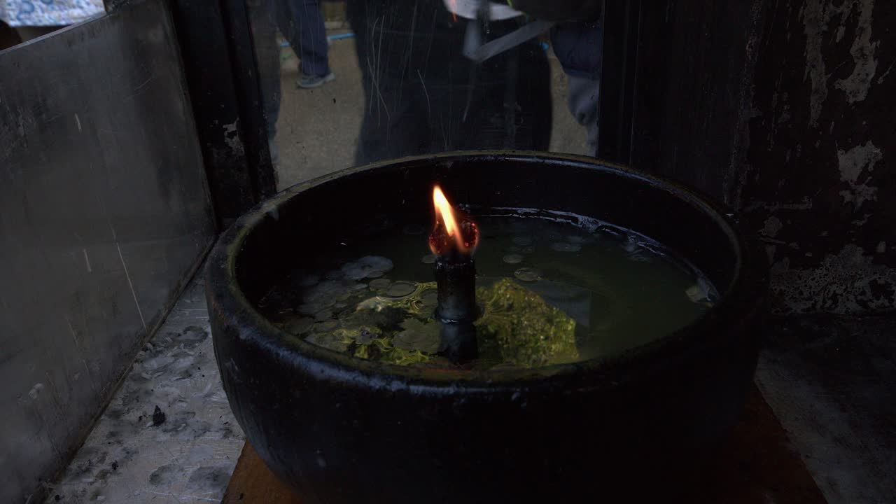 Persona che accende una candela votiva alla fiamma eterna di un tempio shintoista in Giappone