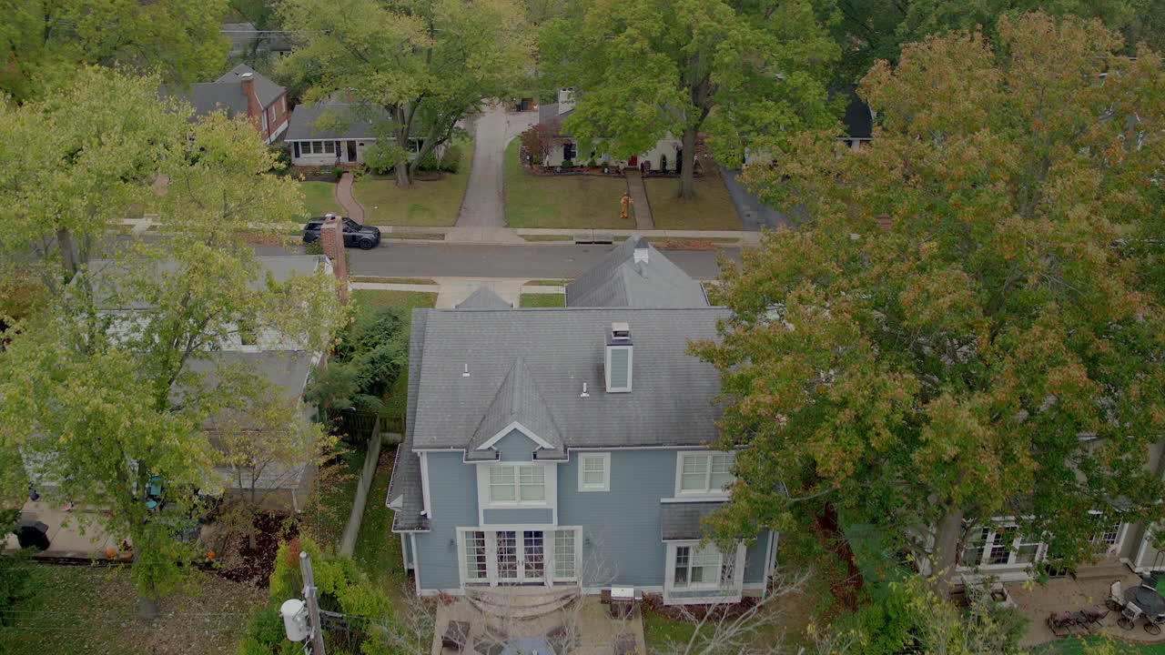 Aerial push over houses and street in suburban neighborhood on an Autumn day