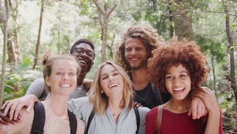 Portrait-Of-Smiling-Young-Friends-Hiking-Through-Countryside-Together