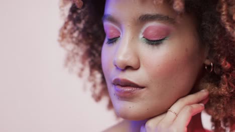 mujer biracial con cabello oscuro en luz azul y rosa, cámara lenta