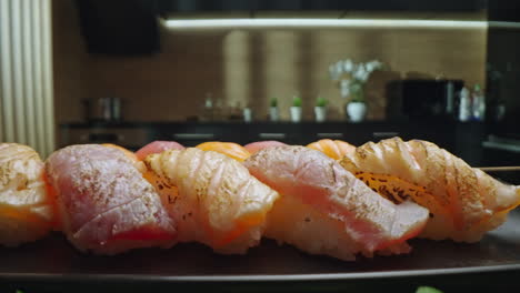 close-up of seared sushi nigiri on a plate in a kitchen