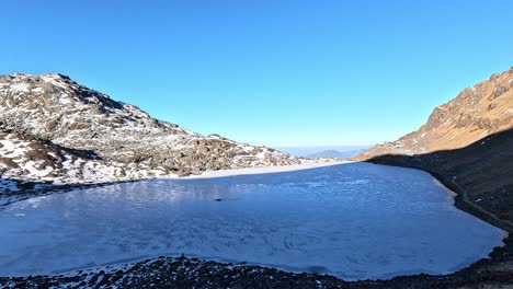 view over the pristine frozen mountain lake in early morning sunlight. gosaikunda holy lake of buddhist and hindu. nepal, lantang national park himalayas