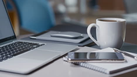 modern workspace setup with laptop, coffee, and tech gadgets