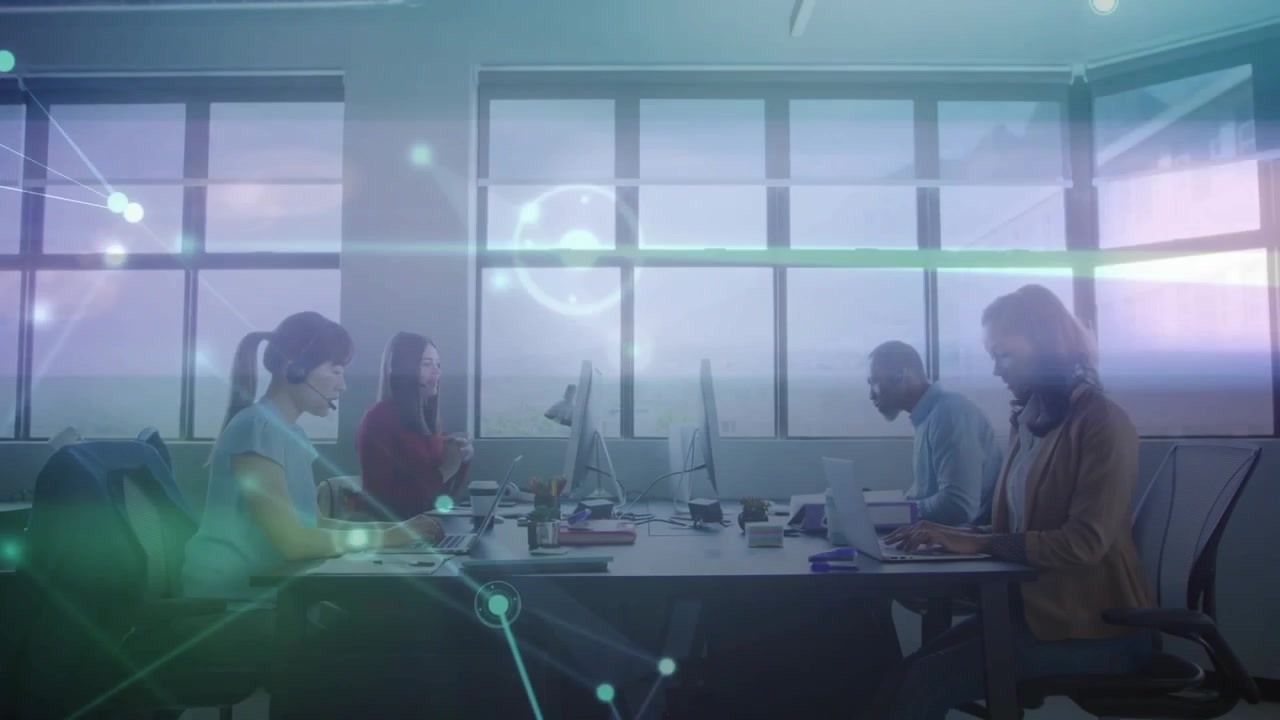 Kolleger taster ved arbejdsstationer, aktiverer glødende netværkslinjer, der illustrerer et falmende teknisk dataflow.
