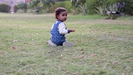 cute toddler trying to stand at park green grass from different angle