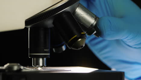 side view of of a scientist working with a microscope in the lab 2