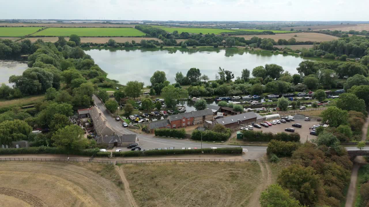 Vista aerea da drone che mostra il traffico fluviale di barche strette e piccoli yacht lungo un paesaggio rurale a Great Addington, Inghilterra, Regno Unito