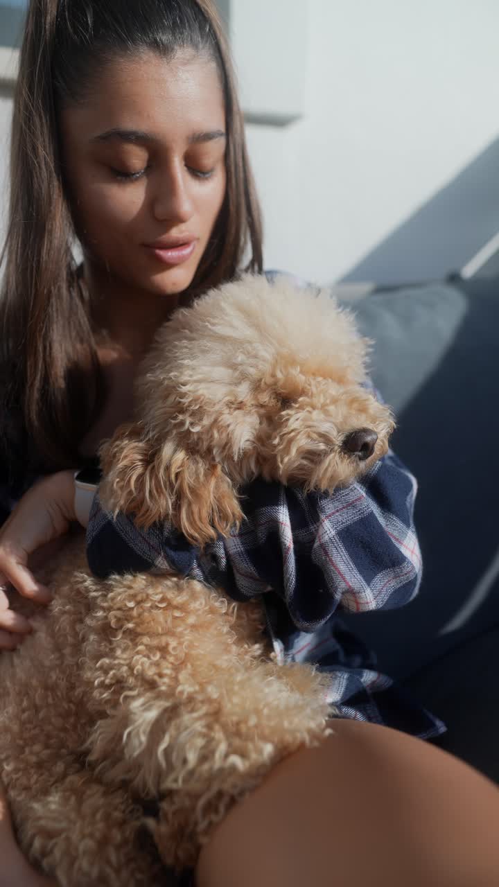 una mujer acurrucando a un caniche.