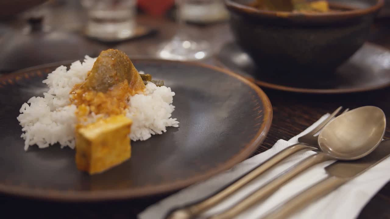 Spooning Tofu Curry on to Rice at the Restaurant