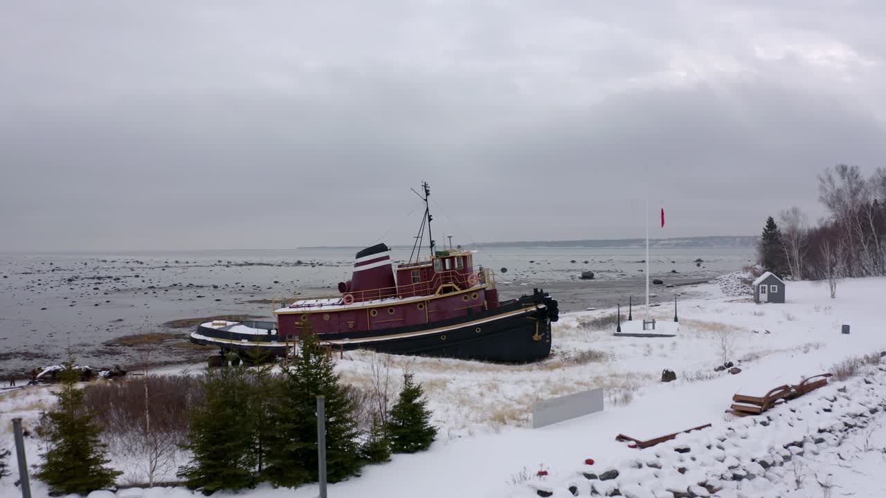 drone volando sobre un barco viejo y revelando el gran río san lorenzo en invierno