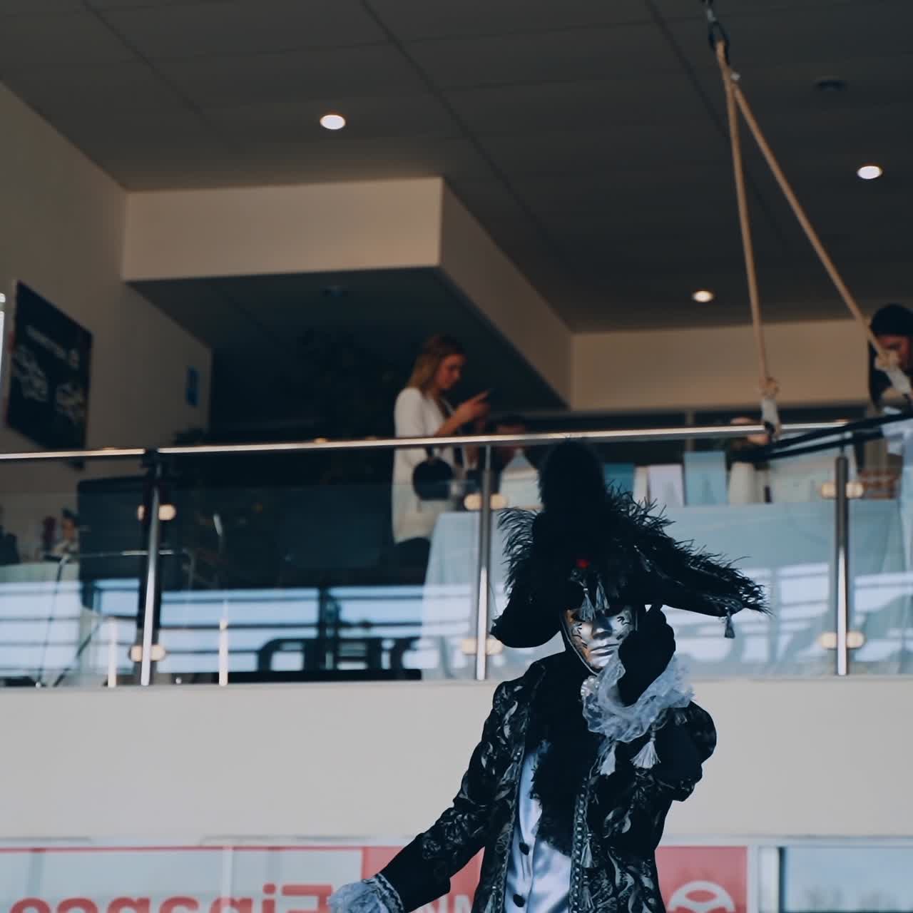 Beautiful masquerade show indoors. Woman and man in masks and carnival costumes in the show programme.