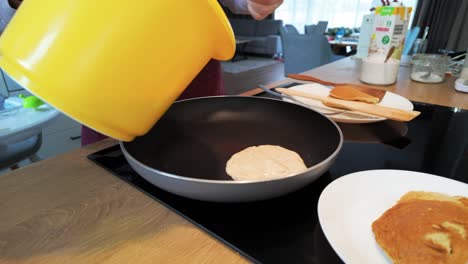 fotografía de cerca de una mujer preparando panqueques en la cocina en casa por la mañana para el desayuno