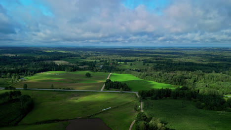 woodland flatlands and clouds in latvia, aerial drone ascend over clouds view