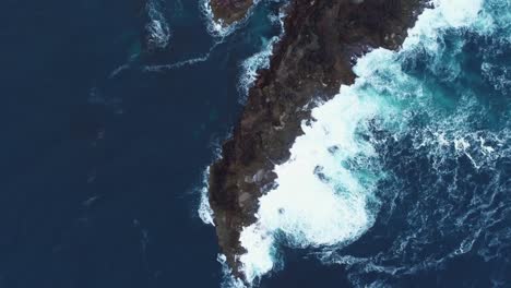 aerial view of dramatic coastline with waves crashing on rocks