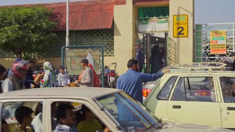 vibrant and bustling scene of a crowded market entrance swarming with people of all ages engaged in various activities amidst a kaleidoscope of stalls, shops, and vendors, islamabad, pakistan.