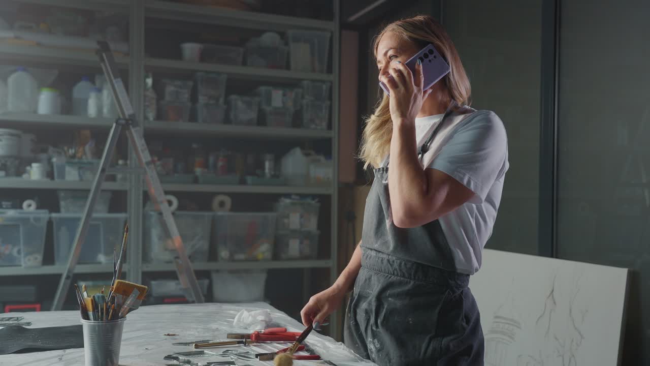 Woman Artist Talking on Phone in Studio