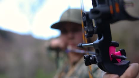 woman aiming at a target and preparing to shoot a bow and arrow