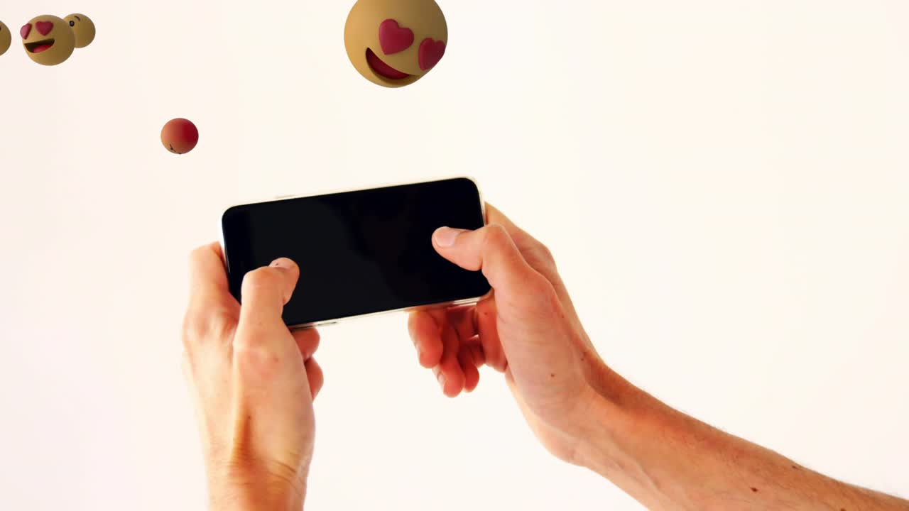 Hands tapping phone touchscreen releasing emoji forming playful reaction cloud before dispersing