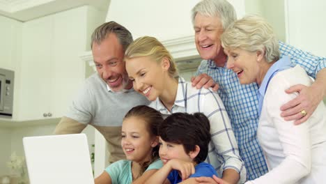 Familia-Usando-Una-Computadora-Portátil-Juntos-En-La-Cocina