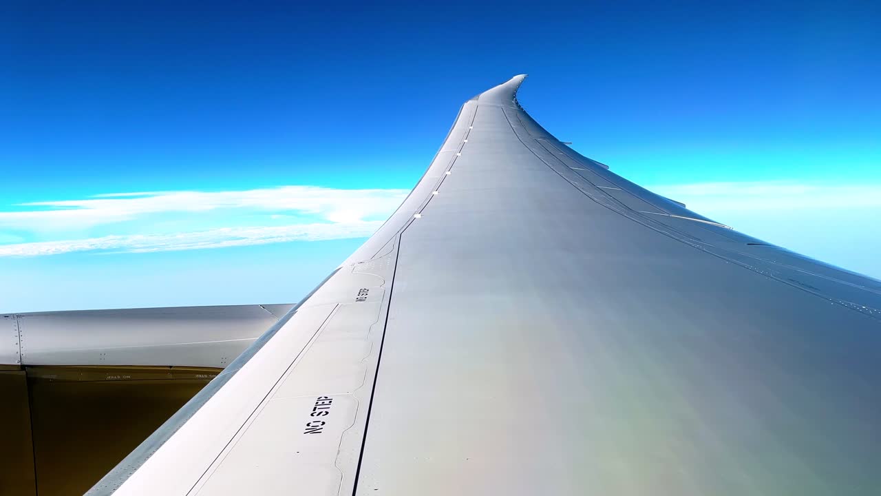 Minimalist aerial view of a modern airplane wing soaring above clouds and blue sky, ideal for travel, aviation, and adventure-themed projects