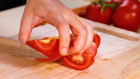 slicing tomatoes on a wooden cutting board