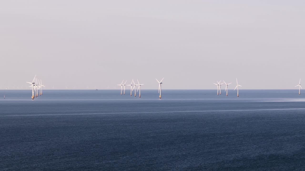 Distant wind turbines on calm sea near Whitstable evoke serenity