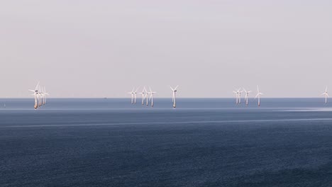 distant wind turbines on calm sea near whitstable evoke serenity