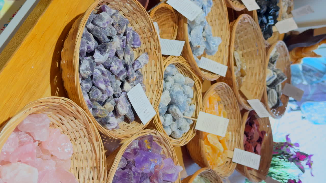 Display with gem stones in baskets in an esoteric shop. Vertical video.
