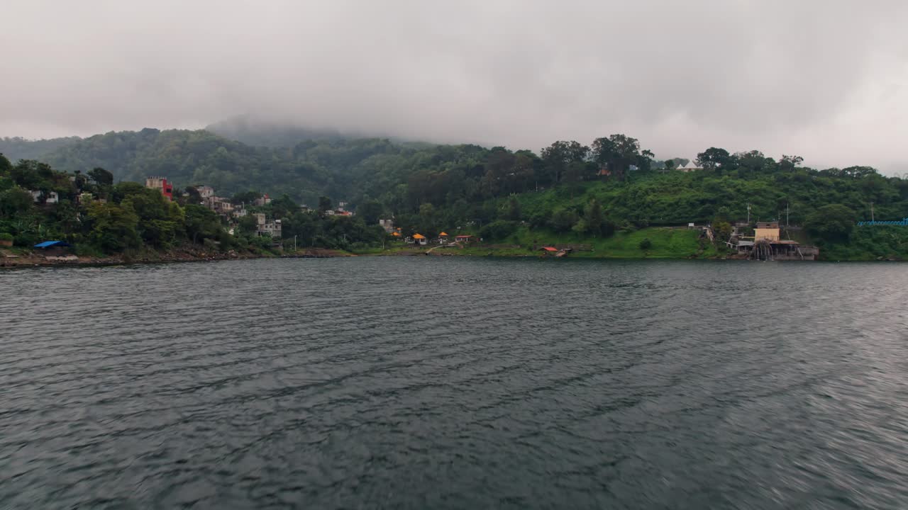 A spectacular drone shot captures the vibrant, art-filled village of Santa Catarina Palopó on the shores of Lake Atitlán at sunrise