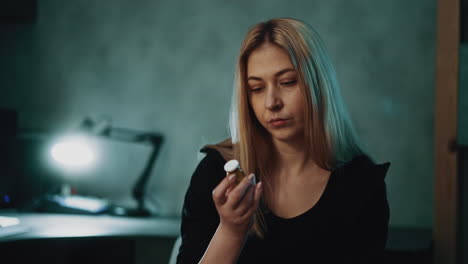una señora escéptica mira con dudas a la droga en una habitación semi-oscura