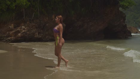 the caribbean island of trinidad: a hispanic girl in a bikini enjoys walking on the white sand beach.