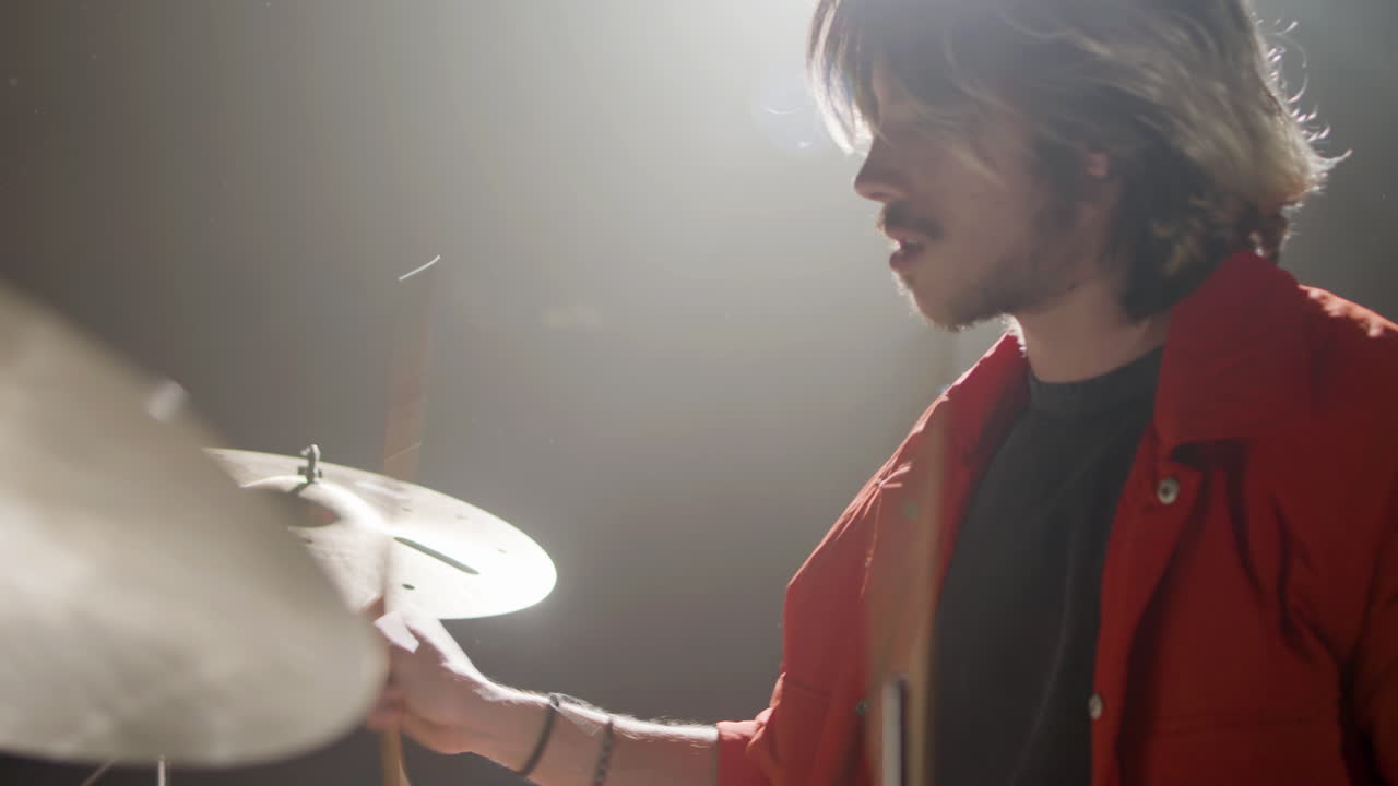 joven baterista tocando la batería en un estudio de música
