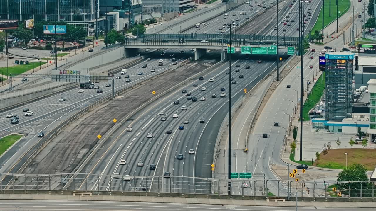 Aerial wide shot of traffic scene in american highway during sunny day. Busy rush hour in metropolis with multi line intersection.