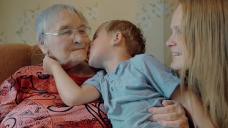 niño expresando amor a su madre y a su abuela con besos