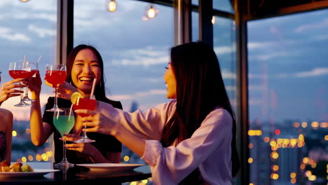 women friends celebrating with cocktails at a rooftop bar