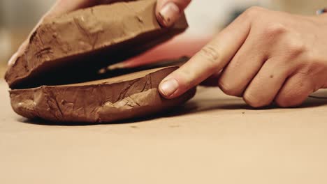 Person-cutting-fresh-clay-block-with-string,-close-up-view