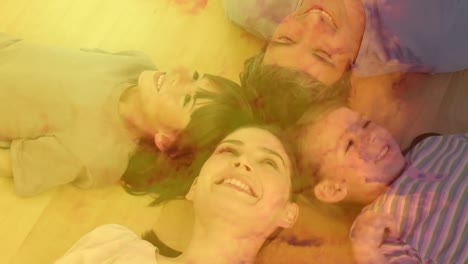animación de una pareja con un hijo y una hija tendidos en el suelo, sonriendo con nubes anaranjadas.