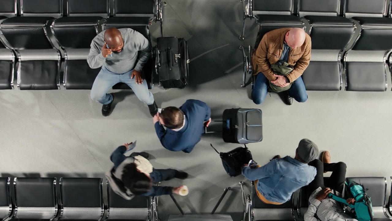 Reading plane departure time schedule on screen, top down view and travelers