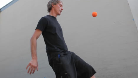 a man juggles balls with his feet